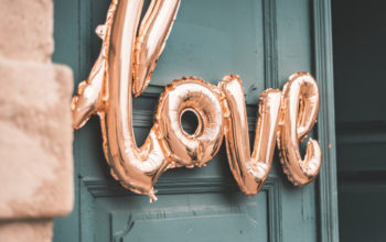 Love shaped balloons in front of wooden door, wedding theme