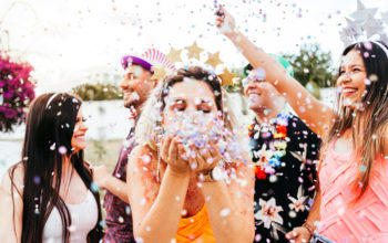 Brazilian Carnival. Young woman in costume enjoying the carnival party blowing confetti